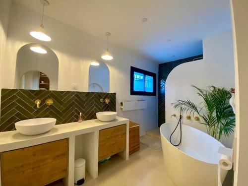 une salle de bain avec deux lavabos et une baignoire dans l'établissement Magnifique Villa avec piscine proche plage, à Six-Fours-les-Plages