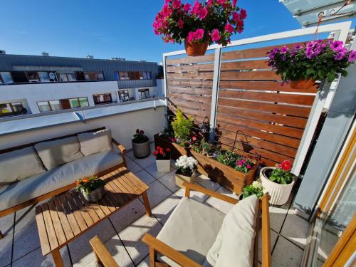 a balcony with a bench and potted plants on it at Appartement Küstenperle in Świnoujście