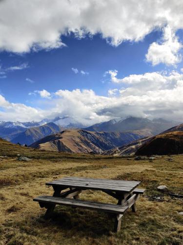 a picnic table on a hill with mountains in the background at Chalet Alexandre in Saint-Sorlin-dʼArves
