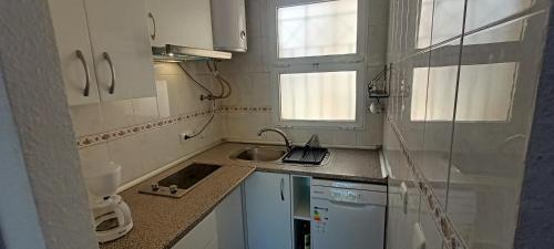 a small kitchen with white cabinets and a sink at San Juan Cozy Home in Benalmádena