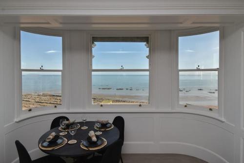 a dining room with a table and a view of the beach at Amazing Seaview - 2 bedroom, 2 bathroom in St. Leonards