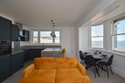 ein Wohnzimmer mit einer Couch und einem Tisch mit Stühlen in der Unterkunft Amazing Seaview - 2 bedroom, 2 bathroom in St. Leonards