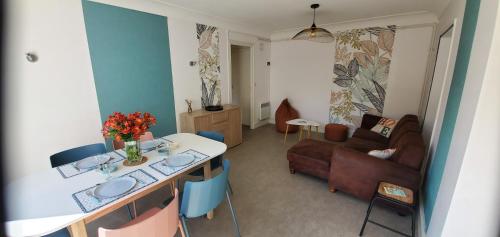 un salon avec une table et un canapé dans l'établissement Le Transat, à 5 min de la superbe plage du Cap-Coz à Fouesnant, proche des commerces, à Fouesnant