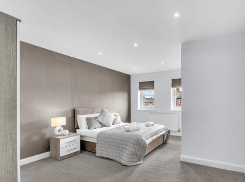 a bedroom with a bed and a wall at Brook Meadow House, 4 bed house, Manchester in Astley