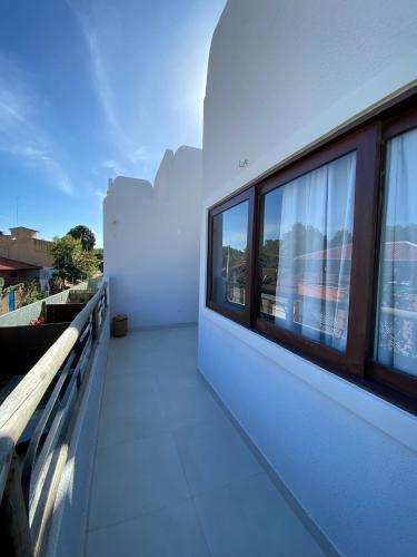 a balcony with windows on a white building at Zenhousepipa in Pipa