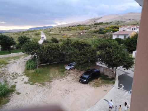 a car parked next to a house with a tree at Tonino apartments in Pag