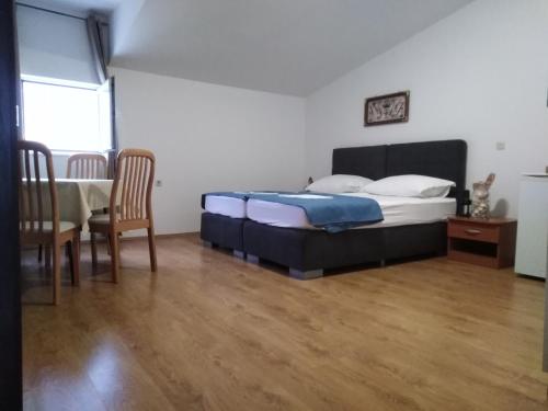 a bedroom with a bed and a table and chairs at Tonino apartments in Pag