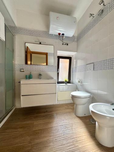 a bathroom with a toilet and a sink and a mirror at PortaLecce B&B in Brindisi