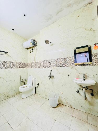 a bathroom with a toilet and a sink at Tom stay - 10 min Walking Distance Nizamuddin Railway Station in New Delhi