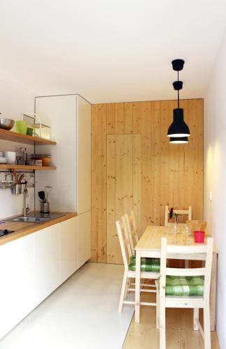 a kitchen with a wooden table and chairs at Garden House in Timişoara