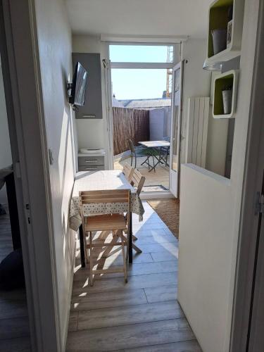 a living room with a table and a television and a door at le val in Pléneuf-Val-André