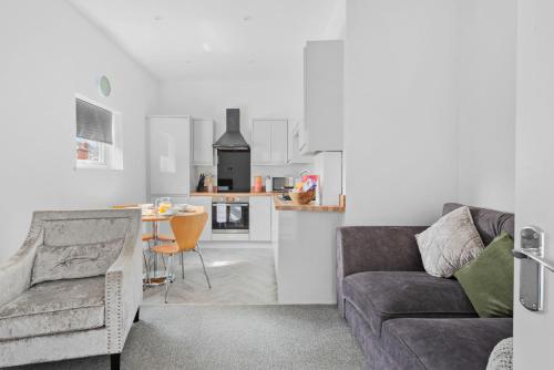 a living room with a couch and a kitchen at Henwood Home Stays I 3 Modern Flats I Sleeps 4 in each in Worcester