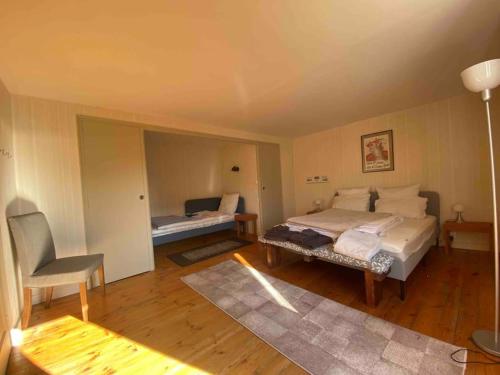 une chambre avec deux lits et une chaise dedans dans l'établissement Maison de caractère 12 couchages - 300m de la plage de sable Location a la semaine en ete, à Binic