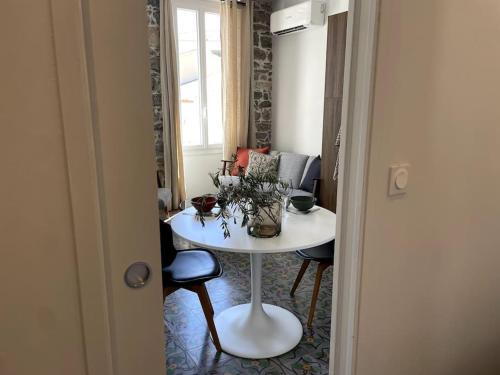 Cette chambre comprend une table et des chaises blanches ainsi qu'un canapé. dans l'établissement Appartement spacieux, confort et climatisé à 500m de la plage, à Carqueiranne