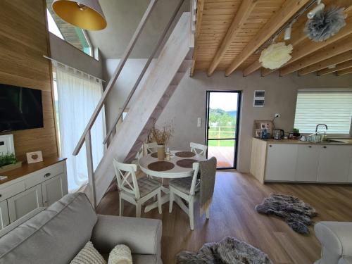 Una sala de estar con mesa y sillas y una cocina. en Chata na rykowisku, en Ustrzyki Dolne