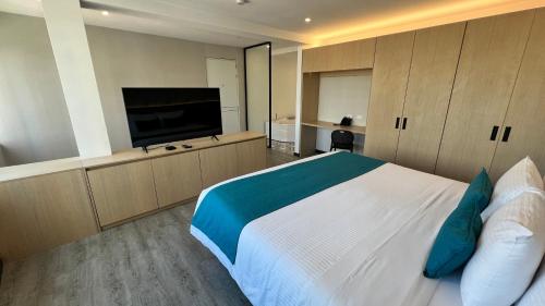 a bedroom with a large bed and a flat screen tv at Hotel Grand Park in Bogotá