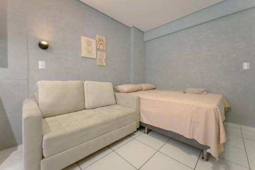 a room with a couch and a table and a chair at Apto Piscina Academia Ar Cond CID108C in Maringá