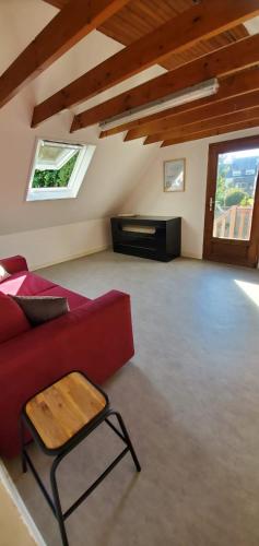 - un salon avec un canapé rouge et un piano dans l'établissement Le Transat, à 5 min de la superbe plage du Cap-Coz à Fouesnant, proche des commerces, à Fouesnant