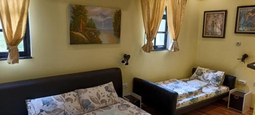 a bedroom with a bed and a chair and windows at Hostel Ruler in Belgrade