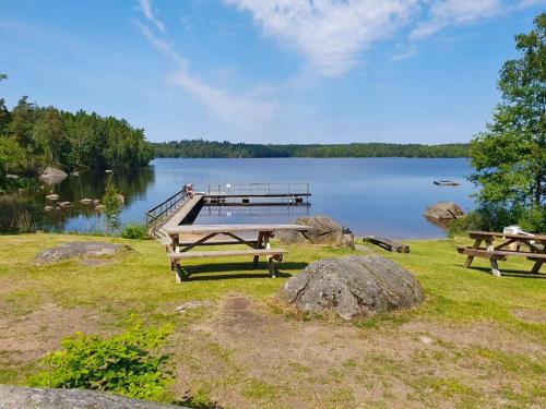 a picnic table and a dock on a lake at 4 star holiday home in KARLSKRONA in Karlskrona