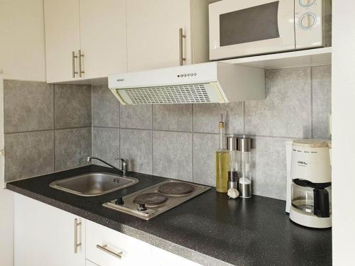 a kitchen with a sink and a microwave at 4 star holiday home in KARLSKRONA in Karlskrona