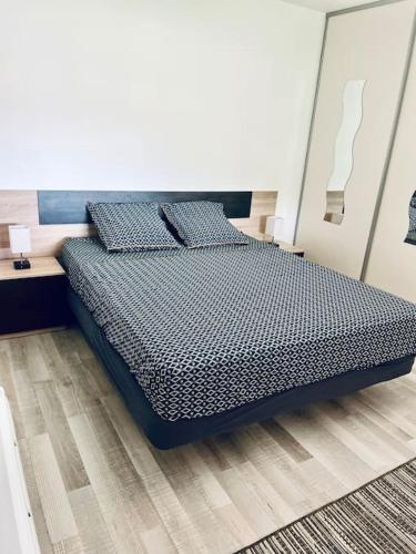 une chambre avec un lit dans une pièce blanche dans l'établissement le 29 - Appartement au coeur du vignoble champenois, à Damery