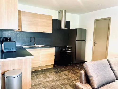 une cuisine avec un réfrigérateur noir et une cuisinière dans l'établissement le 29 - Appartement au coeur du vignoble champenois, à Damery