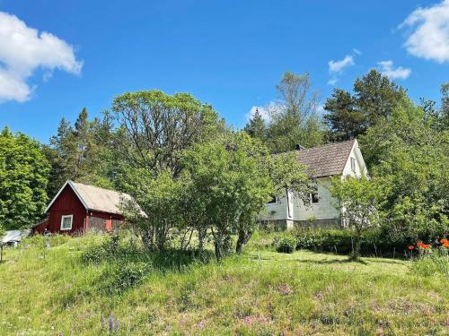 an old house and a red barn in a field at 4 person holiday home in ASARUM in Asarum
