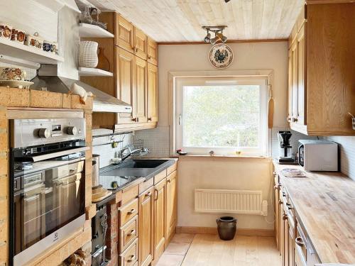 a kitchen with wooden cabinets and a window at 9 person holiday home in HUDDINGE in Huddinge