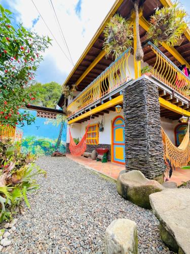 a home with a colorful house with a garden at Casa de las Rocas Hostel in Jardin