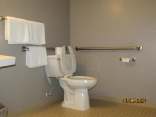 a bathroom with a toilet with towels on the wall at Motel 6-West Des Moines, IA in West Des Moines