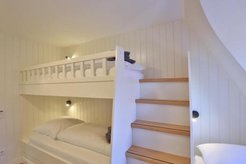 a bedroom with a bunk bed and a staircase at Strandvilla Marina 28 - Traumblick in Wangerooge