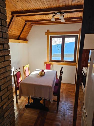 a dining room with a table and chairs and a window at Planinski vrh in Bajina Bašta