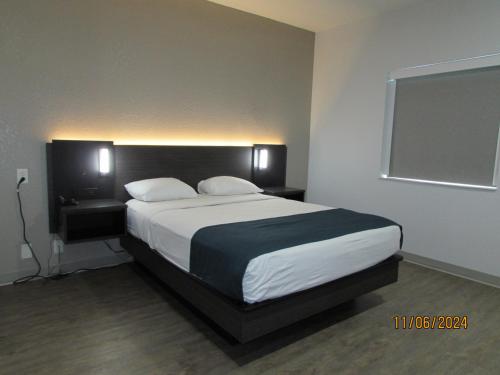 a bedroom with a large bed with two pillows at Motel 6-West Des Moines, IA in West Des Moines