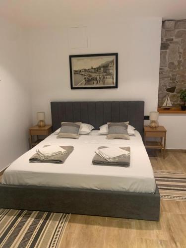 a bedroom with a large bed with white sheets at Room Riboli in Makarska