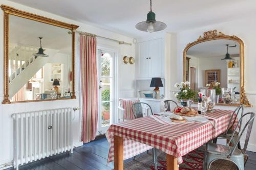 ein Esszimmer mit Tisch und Spiegel in der Unterkunft Mariner's Cottage by Coaste in Deal