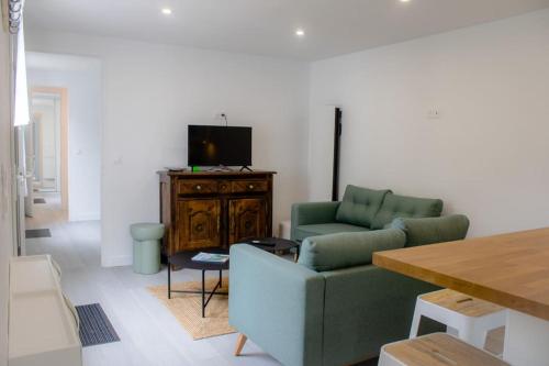 a living room with a couch and a tv at Ty Dany-wifi-plage à pieds in Crozon