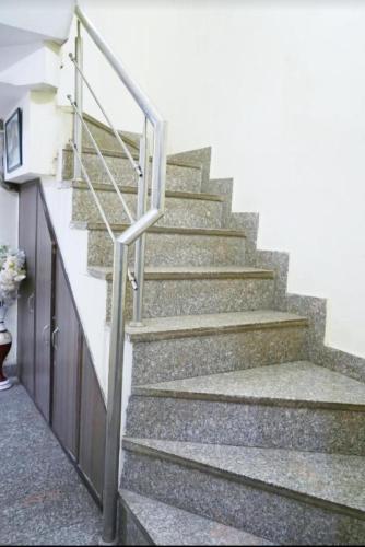 a set of stairs with a metal hand rail at Tom stay - 10 min Walking Distance Nizamuddin Railway Station in New Delhi