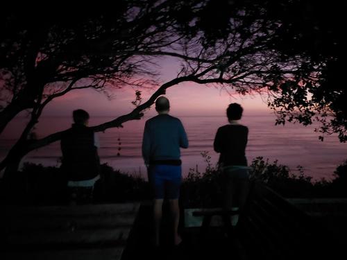 a group of three people looking at the sunset at Gulls Way in Keurboomstrand