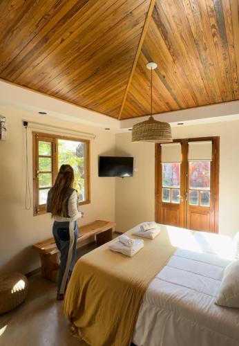 a woman standing in a bedroom with a large bed at Tanah Host - Casa de Huespedes in Villa Mercedes