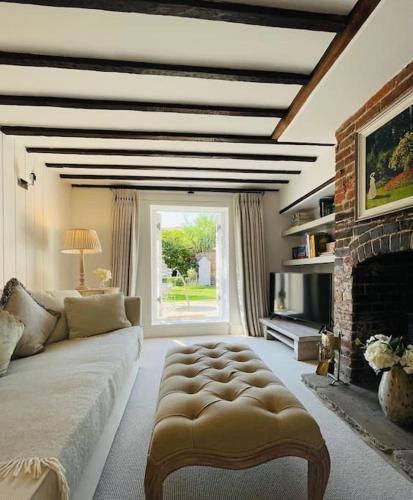 a living room with a couch and a fireplace at Beautiful 18th century cottage in Arundel in Arundel