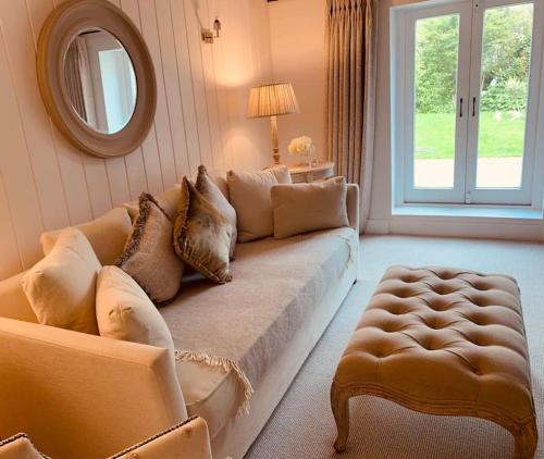 a living room with a couch and a mirror at Beautiful 18th century cottage in Arundel in Arundel