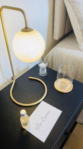 a table with a lamp and a paper on it at Vila Casarão - Casa de Hóspedes in Caravellas