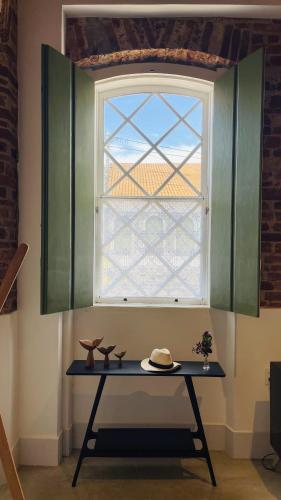 a table in a room with a window at Vila Casarão - Casa de Hóspedes in Caravellas