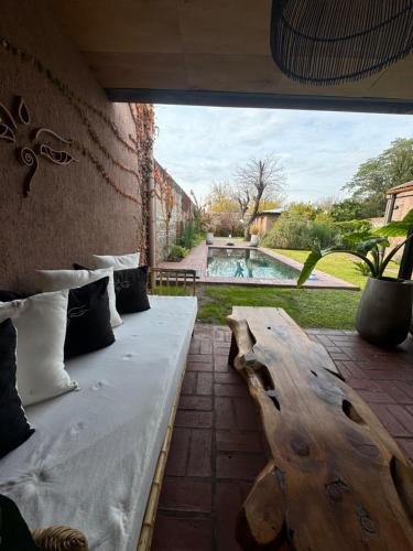 a room with a bed and a table and a pool at Tanah Host - Casa de Huespedes in Villa Mercedes