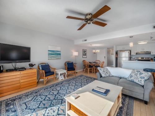 a living room with a couch and a flat screen tv at Sunskipper #6G - At Ease in Carolina Beach