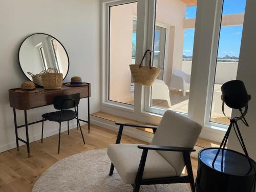 - un salon avec un miroir, une table et des chaises dans l'établissement Appartement terrasse centre ville, à La Rochelle