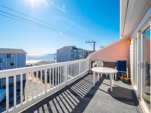 a balcony with a table and a view of the beach at Sunskipper #6G - At Ease in Carolina Beach