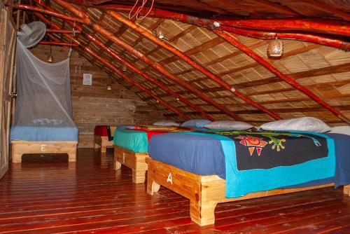 a room with three beds in a wooden structure at Hostel La Ballena Backpacker in Las Galeras