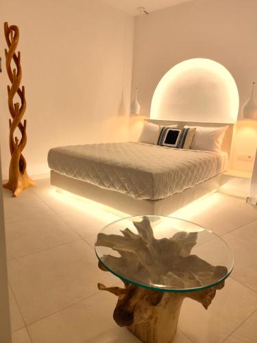 a bedroom with a bed and a glass table at The Magic Luxury Cave Suites in Vóthon